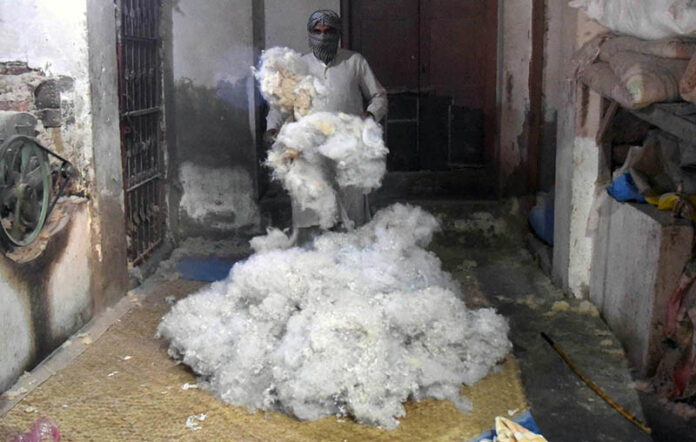 A worker processing cotton to be used for the preparation of quilts on the eve of winter season at his workplace.