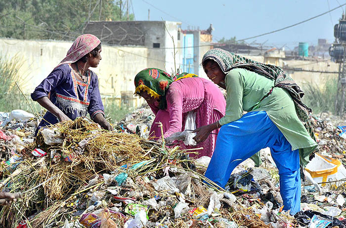 Gypsy women searching the valuables items from garbage at Latifabad.